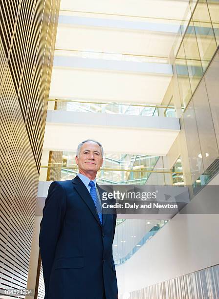 smiling businessman in lobby - one man only stock pictures, royalty-free photos & images