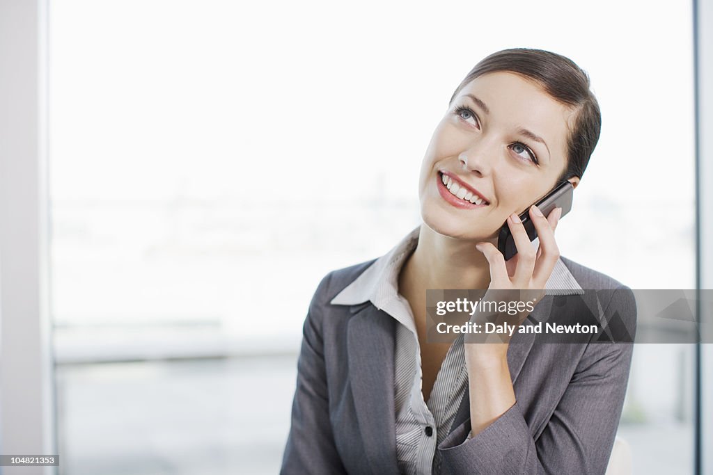 Smiling businesswoman talking on cell phone