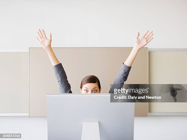 surprised businesswoman with arms raised looking at computer - exhilaration imagens e fotografias de stock