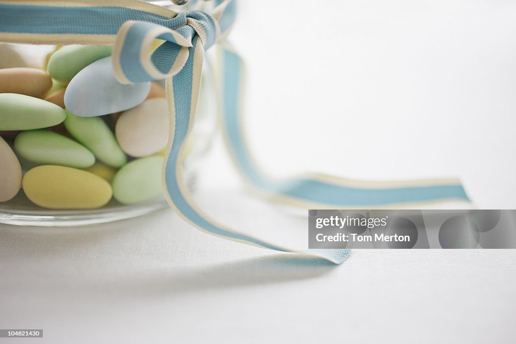 Close up of pastel candies in jar with ribbon