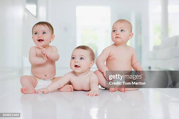 smiling babies on floor - babies in a row stock pictures, royalty-free photos & images