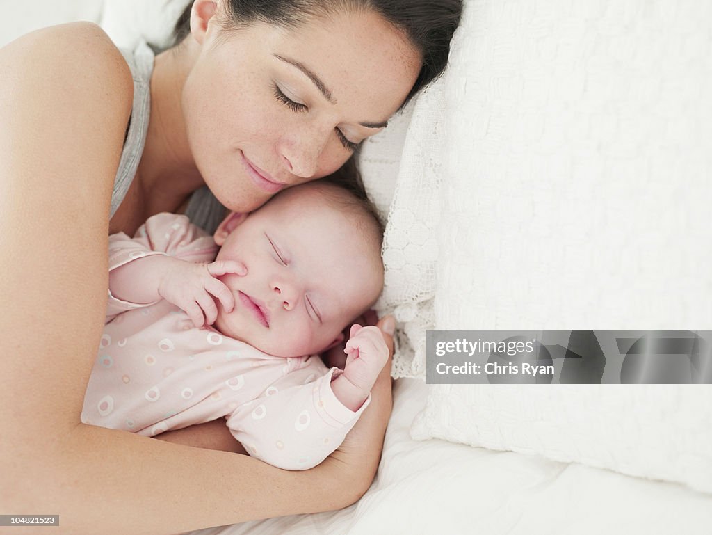 Mother and baby sleeping in bed