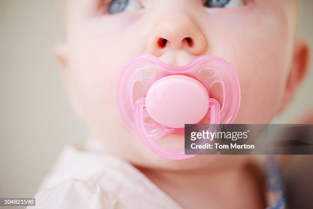 close up of baby with pink pacifier - pacifier stockfoto's en -beelden