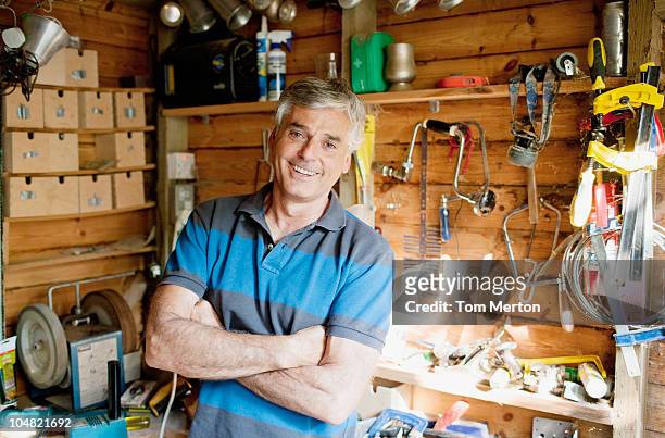 smiling man surrounded by tools in workshop - shed stock pictures, royalty-free photos & images