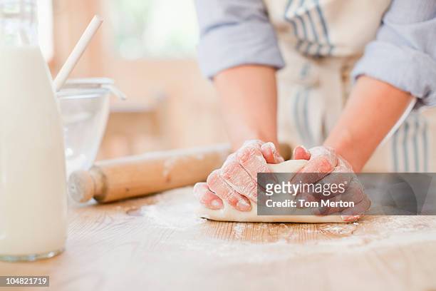 mujer amasado masa sobre mesa de preparación en la cocina - hacer pan fotografías e imágenes de stock