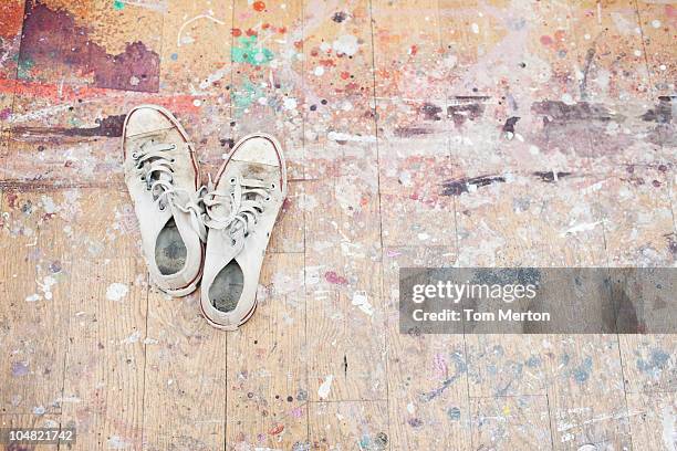 sneakers on paint-spattered wood floor - worn sneakers stock pictures, royalty-free photos & images