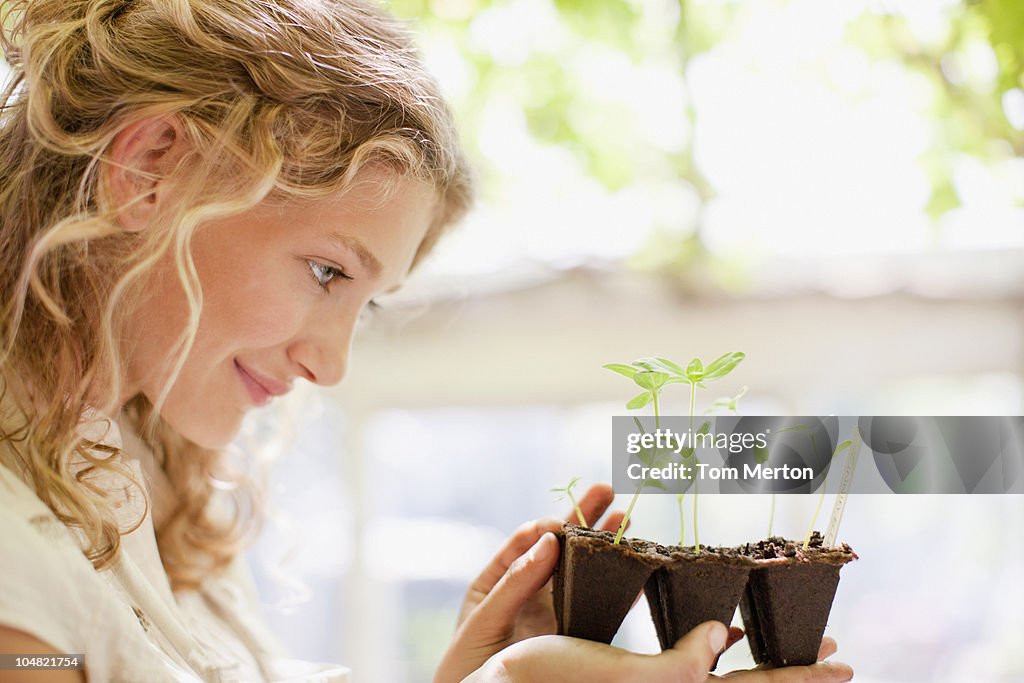 Girl looking at seedlings growing in plastic tray