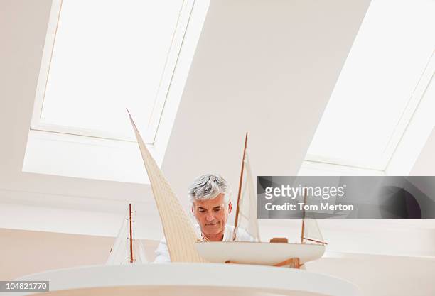 man assembling model sailboat - skylight stock pictures, royalty-free photos & images
