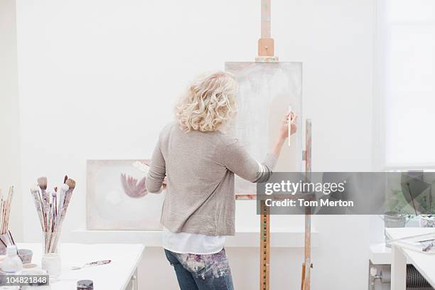 woman painting on canvas in art studio - artist's canvas stock pictures, royalty-free photos & images