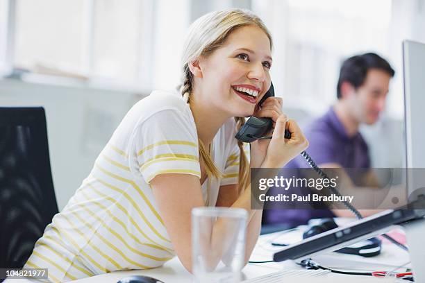 smiling businesswoman talking on telephone in office - landline telephone stock pictures, royalty-free photos & images