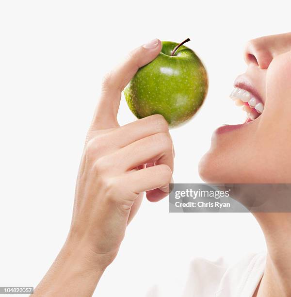 smiling woman eating green apple - mouth open profile stock pictures, royalty-free photos & images