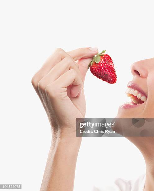 smiling woman eating strawberry - mouth open profile stock pictures, royalty-free photos & images
