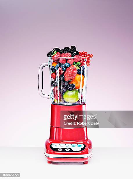 variety of fruit crammed in blender - fruit smoothies stock pictures, royalty-free photos & images