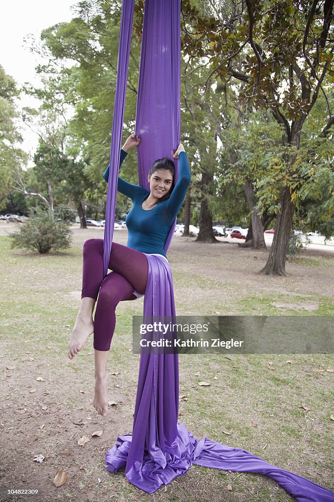 Young woman doing acrobatics in the tree