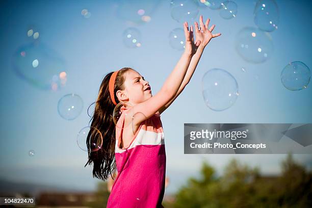 young girl chasing bubbles - girl reaching stock pictures, royalty-free photos & images