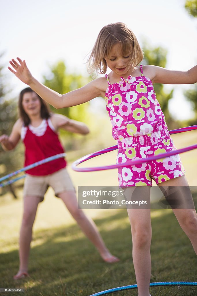 2 young girls playing with hula hoops