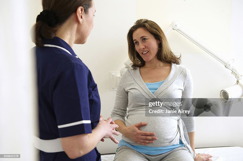 Pregnant woman with nurse in clinic