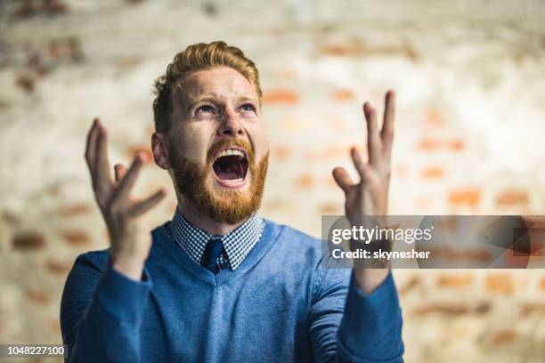 empresario joven pelirroja gritando de frustración. - frustración fotografías e imágenes de stock