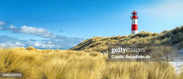 red and white striped lighthouse on sand dunes of island sylt in winter - schleswig holstein stock pictures, royalty-free photos & images