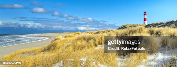 rot-weiß gestreifte leuchtturm auf sanddünen der insel sylt im winter - sylt stock-fotos und bilder