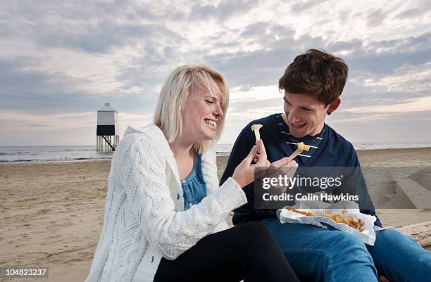 couple on beach eating fish and chips - burnham on sea stock pictures, royalty-free photos & images