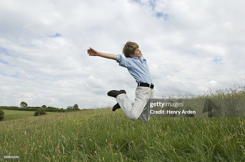 Young boy jumping in field