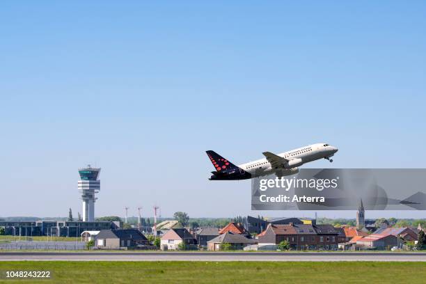 Control tower of Brussels Airport and the village Steenokkerzeel behind runway of Brussels Airlines while airplane is taking off, Zaventem, Belgium.