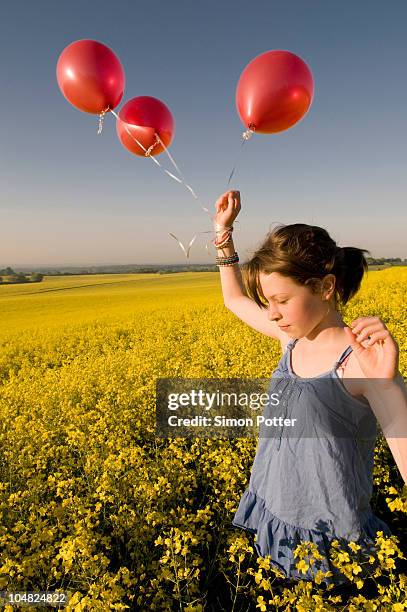 girl walks thru field with balloons - three balloons stock pictures, royalty-free photos & images