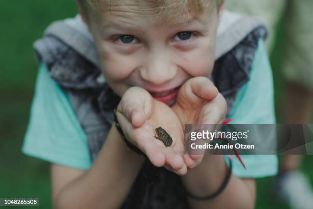 Little boy holding a small toad