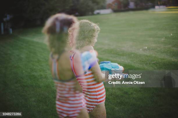 double exposure of a child shooting a squirt gun - double exposure running stock-fotos und bilder