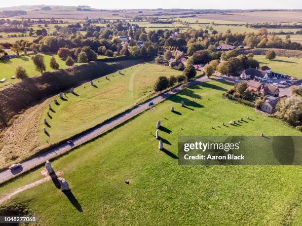 looking down at stone circles in grassy field shot from air. - avebury stock pictures, royalty-free photos & images