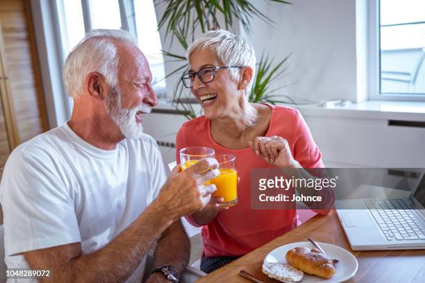 älteres paar haben das frühstück zu hause entspannen - generation x stock-fotos und bilder