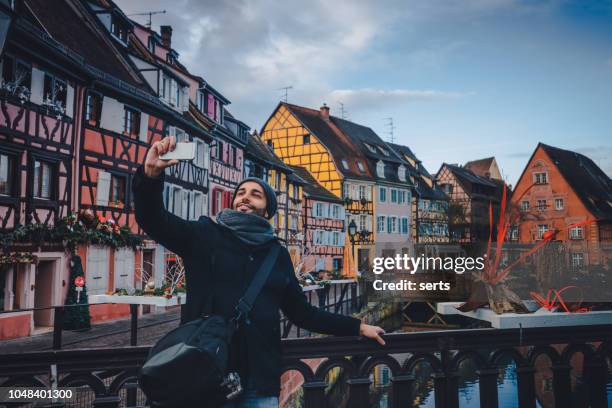 giovane che si fa selfie con lo smartphone a colmar, in francia - alsazia foto e immagini stock