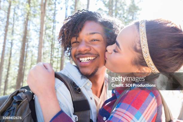 romantische jong koppel wandelen samen - friends kissing cheeks stockfoto's en -beelden