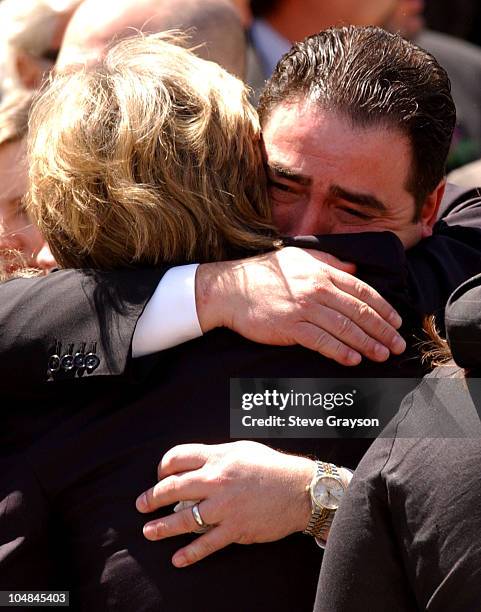 Heather Menzies, widow of actor Robert Urich is comforted by Emeril Lagasse after funeral services for the actor, April 19, 2002.