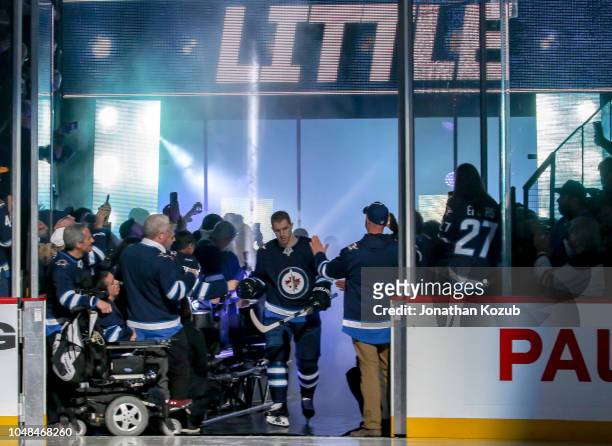 Bryan Little of the Winnipeg Jets hits the ice during the player introductions prior to the home opener against the Los Angeles Kings at the Bell MTS...