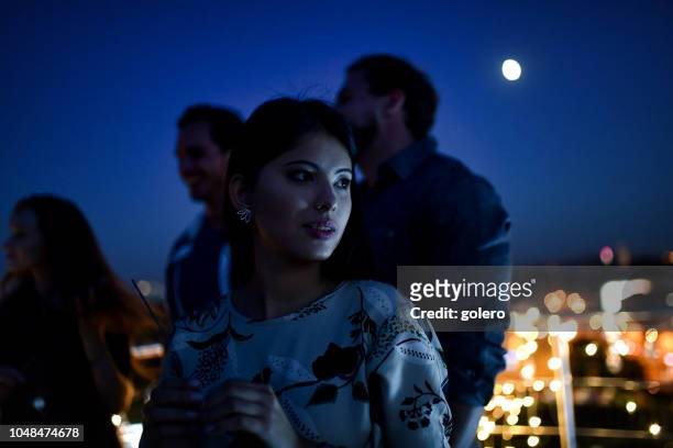 beautiful young woman on rooftop party at night - rooftop party night stock pictures, royalty-free photos & images
