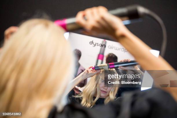 Model demonstrates Dyson Ltd.'s Airwrap product during the company's beauty technology launch event in New York, U.S., on Tuesday, Oct. 9, 2018....