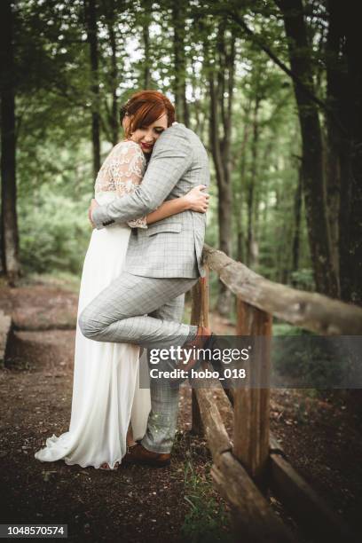 giovane coppia di nozze che abbraccia - white flower field foto e immagini stock