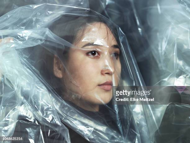 young woman looking through plastic - barriere stock-fotos und bilder