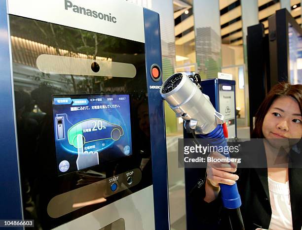 Panasonic Corp. Worker shows its rapid charge system for an electric vehicle at the Panasonic Eco Ideas Forum 2010 at the Panasonic Center, in Tokyo,...
