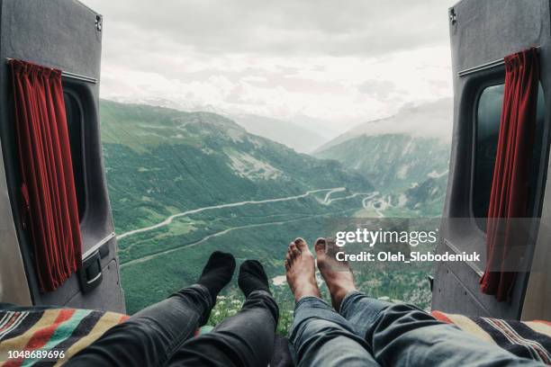 paar leggen met zicht op furkapas - campervan stockfoto's en -beelden