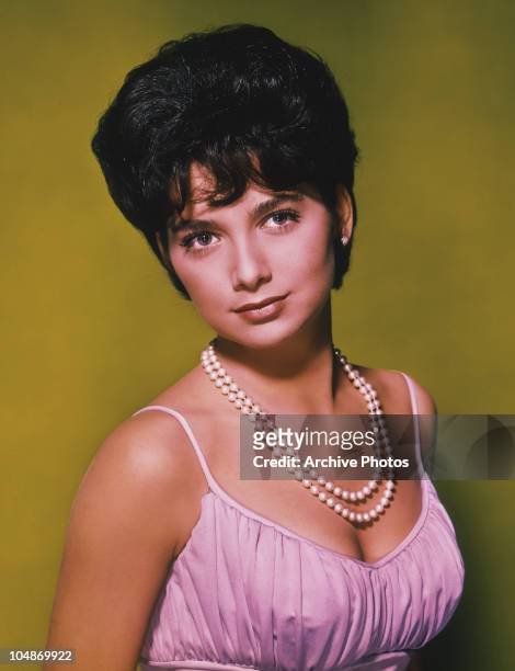 Portrait of American actress Suzanne Pleshette wearing pearls and a pink sleeveless dress circa 1960.