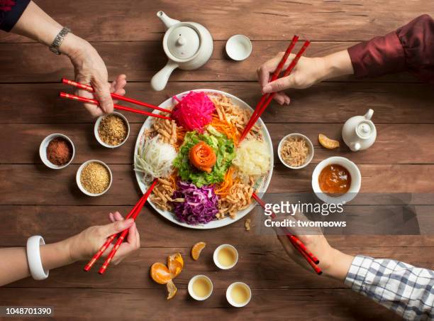 chinese new year food, raw fish salad “yusheng”. - chinese family dinner stock-fotos und bilder