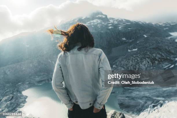 mujer mirando la vista escénica del lago glaciar en los alpes suizos - chaqueta tejana fotografías e imágenes de stock