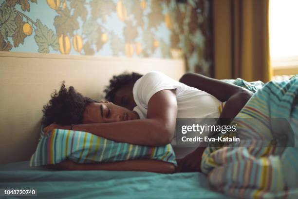 young couple is sleeping back to back - black man sleeping in bed stock pictures, royalty-free photos & images