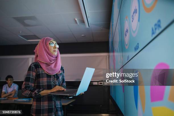 junge frau, die programmierung einer darstellung der daten - globalisierung stock-fotos und bilder