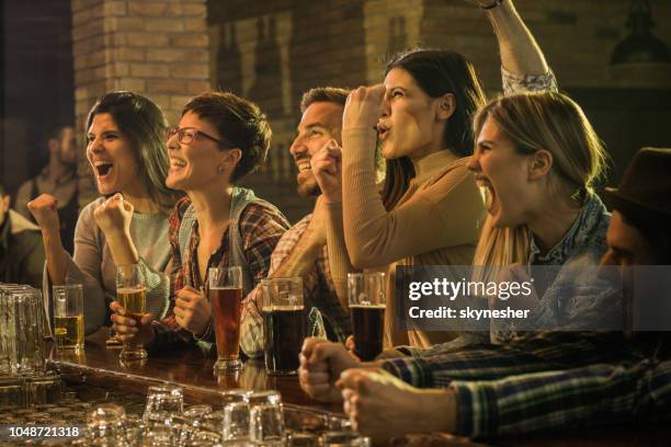 gruppo di tifosi allegri che tifano per la loro squadra in un bar. - tappa foto e immagini stock