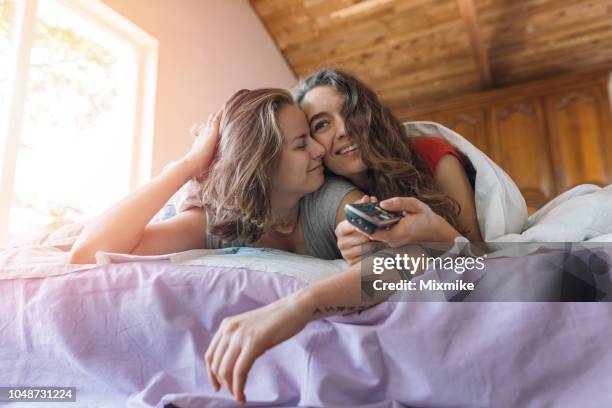 young couple staying lazy in bed - lesbian bed stock pictures, royalty-free photos & images