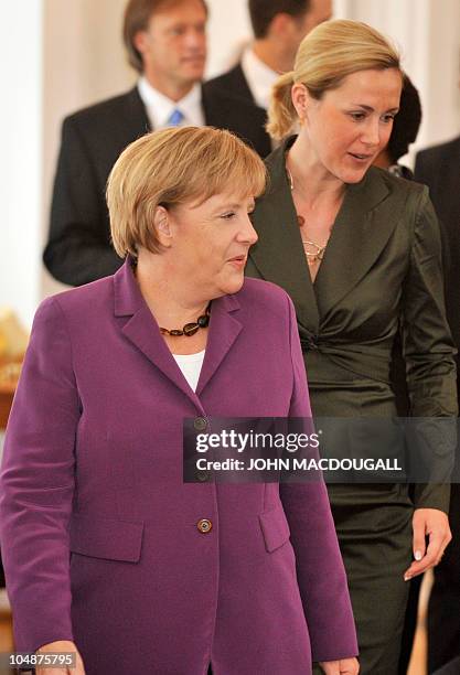 German President Christian Wulff's wife Bettina Wulff and German Chancellor Angela Merkel arrive for a ceremony to honour the German football team at...